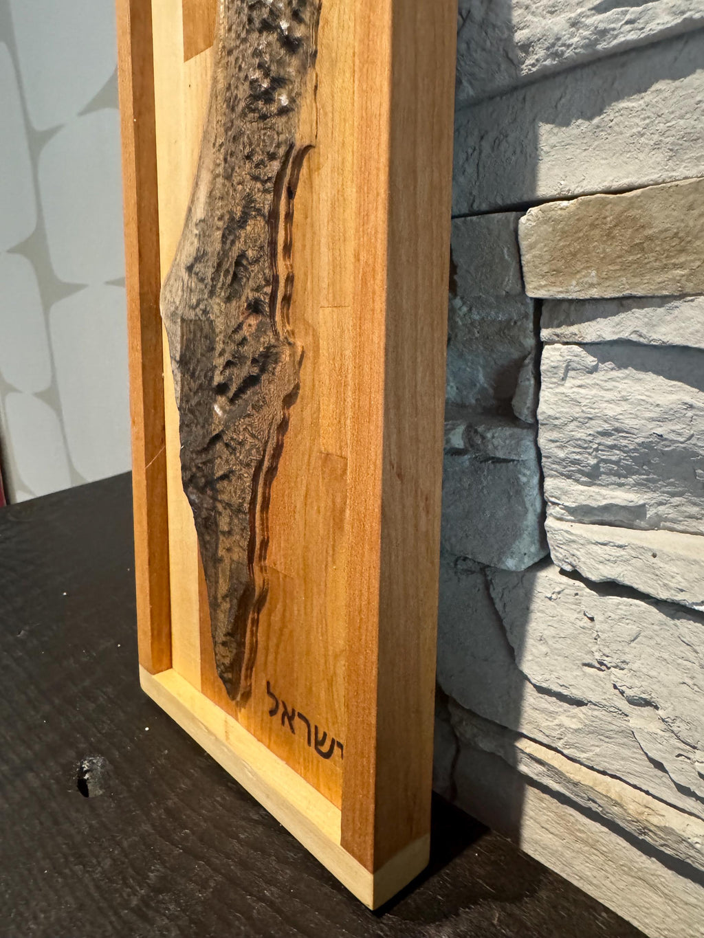 A high-angle close-up looking down at the carved wooden map, emphasizing the contrast between the rough, natural live-edge bark and the smooth, polished wood surfaces. __etsy:8156428696