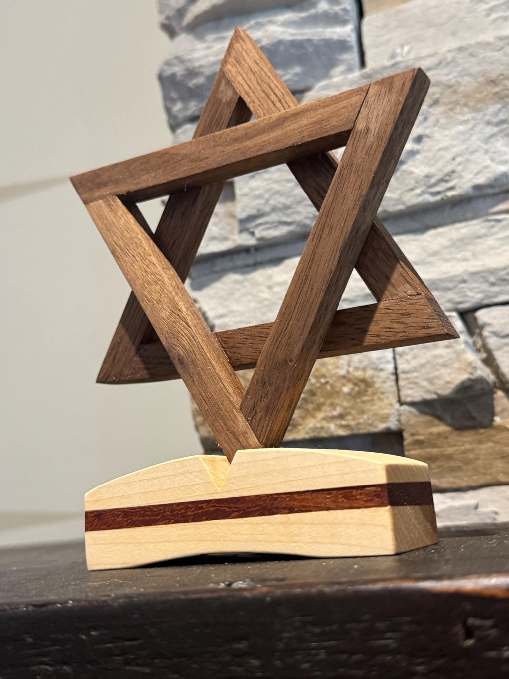 A close-up, angled view of the three-dimensional wooden Star of David sculpture. The interlocking geometric bands showcase smooth, polished finishes and the rich, natural grain patterns of the premium hardwoods. __etsy:8204393829