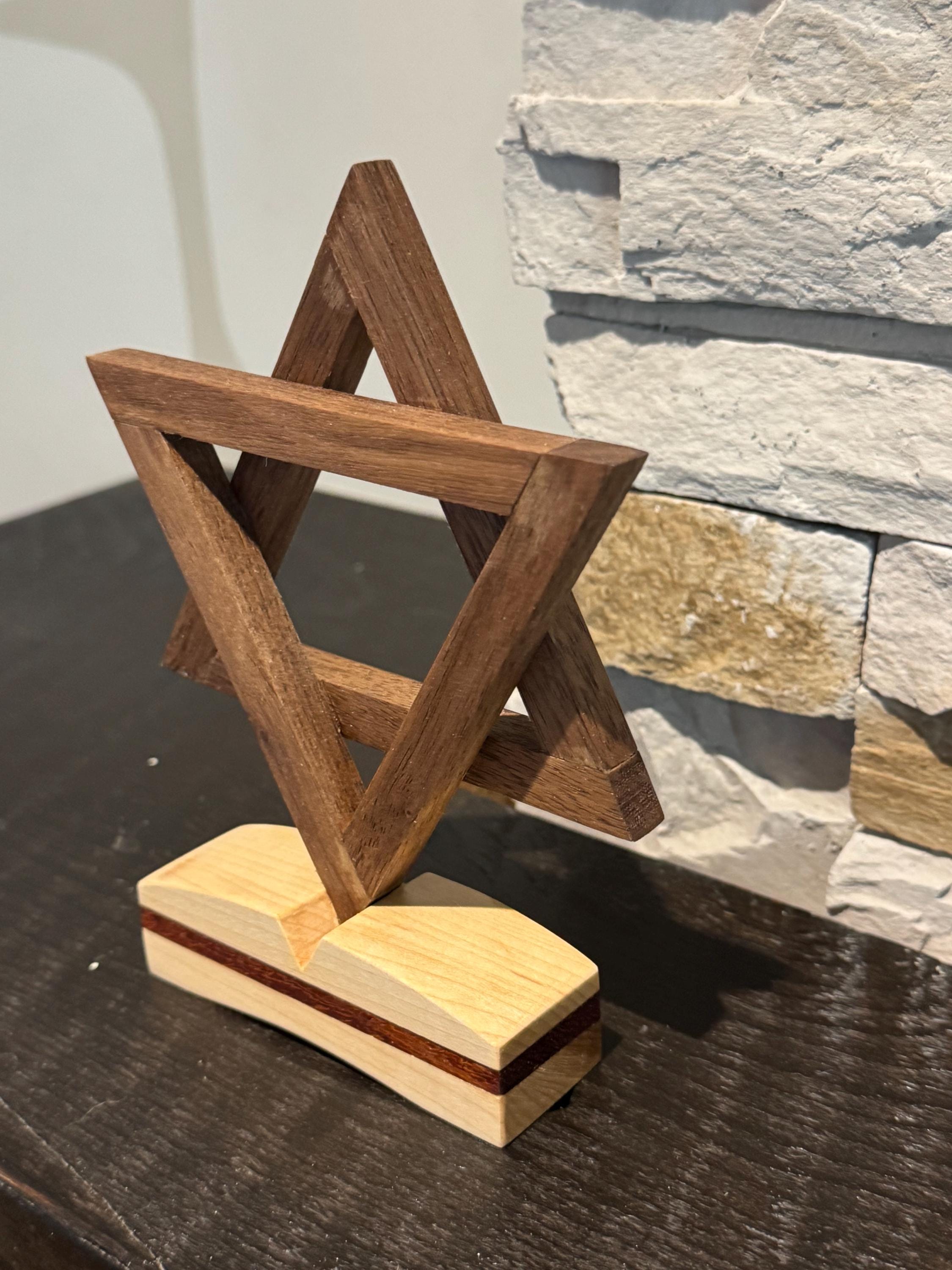 An angled three-quarter view of the wooden Magen David sculpture, beautifully showcasing the vibrant reddish-orange hues of the Padauk wood intertwined with darker walnut and lighter maple wood tones. __etsy:8156470266
