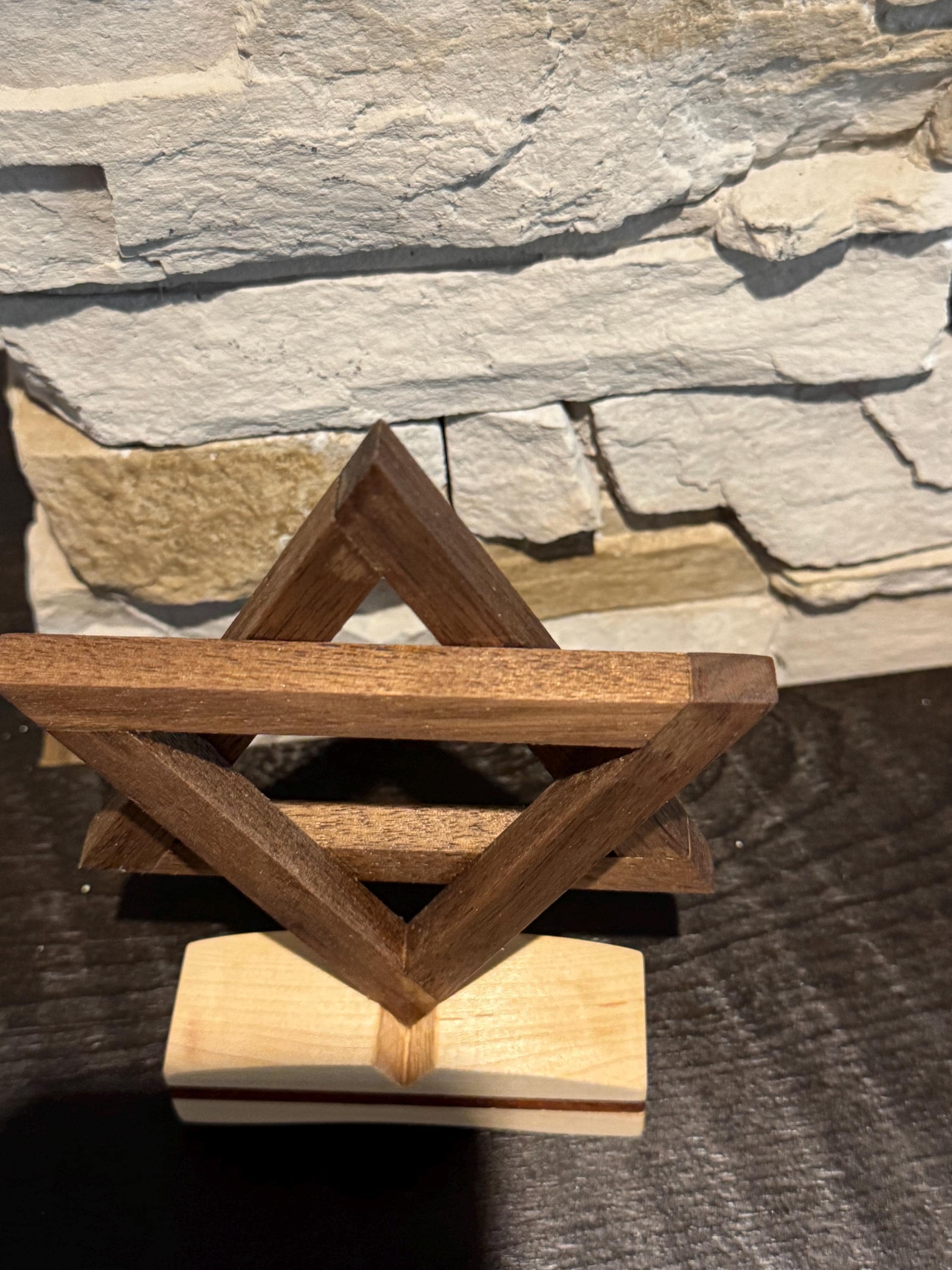 A high-angle side view of the handcrafted wooden Star of David art piece. The perspective emphasizes the thick, sturdy build of the interlocking star shapes and the contrasting layers of the multi-toned wooden base. __etsy:8204394283